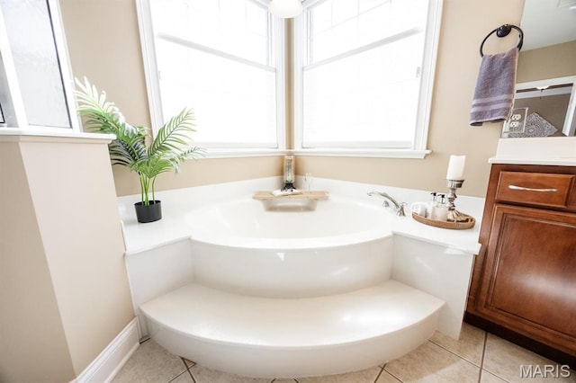 full bath with tile patterned floors, a garden tub, and vanity