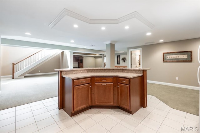 kitchen featuring light carpet, open floor plan, recessed lighting, brown cabinets, and light stone counters