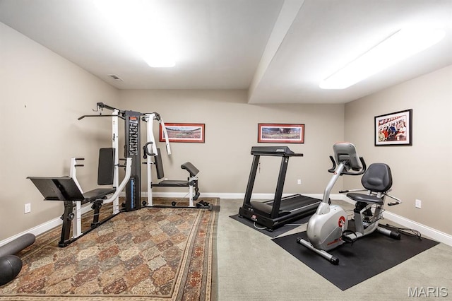 exercise room with baseboards and carpet flooring