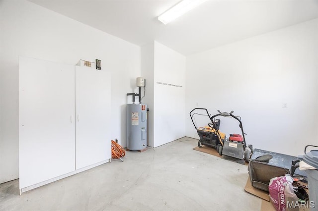 misc room featuring water heater and unfinished concrete flooring