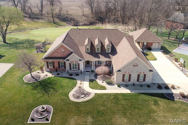 view of front facade with stone siding, driveway, and a front yard