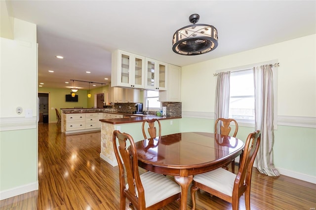 dining space featuring baseboards, wood finished floors, and recessed lighting