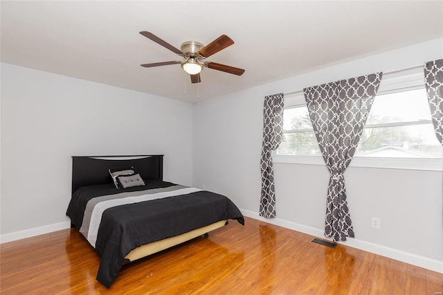 bedroom with baseboards, light wood-style floors, and ceiling fan
