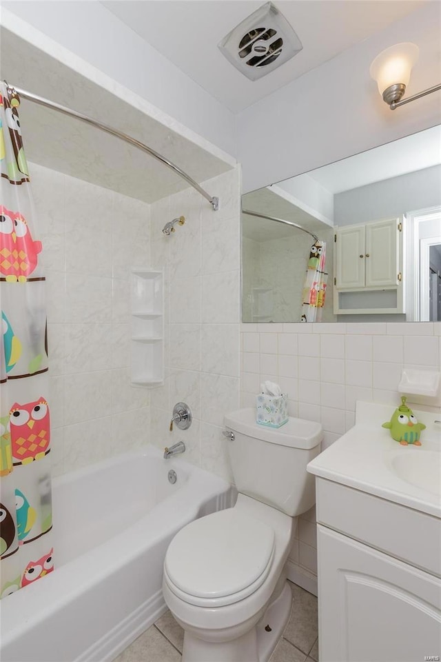 bathroom with tile patterned floors, shower / bath combination with curtain, vanity, toilet, and tile walls