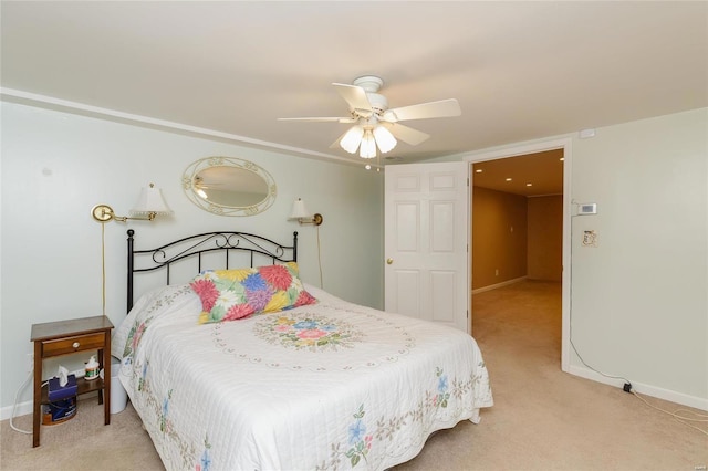 bedroom featuring light colored carpet, baseboards, and a ceiling fan