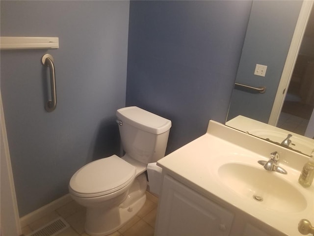 half bathroom with toilet, tile patterned floors, and vanity
