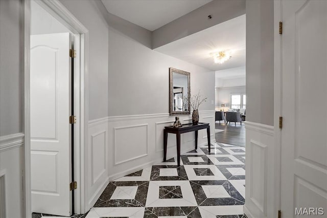 561 Sarah Ln Unit 305, Saint Louis, MO 63141 - hall featuring a wainscoted wall, dark tile patterned floors, inlaid floor details, and a decorative wall