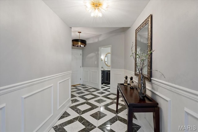 561 Sarah Ln Unit 305, Saint Louis, MO 63141 - hallway featuring inlaid floor details, a decorative wall, wainscoting, and light tile patterned flooring