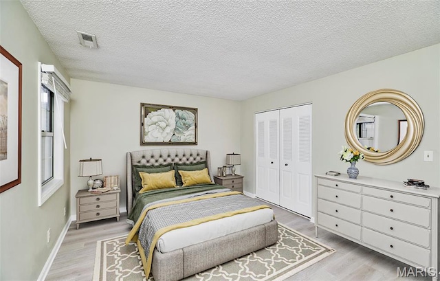 9167 Robin Ct, Saint Louis, MO 63144 - bedroom featuring light wood-type flooring, a closet, a textured ceiling, and baseboards
