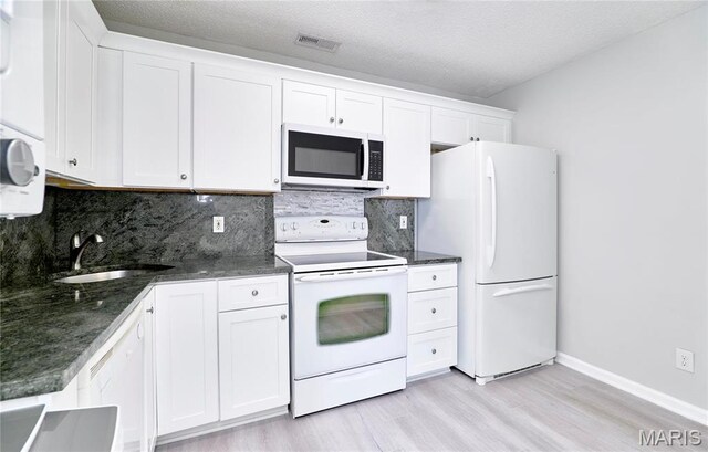 9167 Robin Ct, Saint Louis, MO 63144 - kitchen with white appliances, a sink, light wood-type flooring, white cabinets, and tasteful backsplash