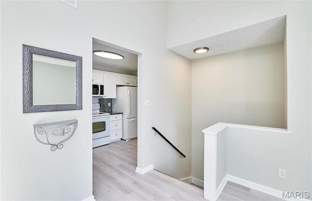 9167 Robin Ct, Saint Louis, MO 63144 - corridor featuring an upstairs landing, light wood-style floors, and baseboards