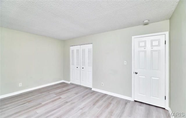 9167 Robin Ct, Saint Louis, MO 63144 - unfurnished bedroom with wood finished floors, a closet, a textured ceiling, and baseboards