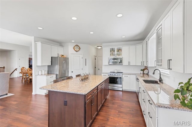 2 Wyndemere Ct, Lake St Louis, MO 63367 - kitchen with stainless steel appliances, a sink, white cabinets, glass insert cabinets, and dark wood-style floors