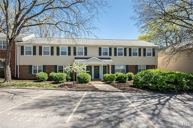 view of front of home featuring brick siding and uncovered parking