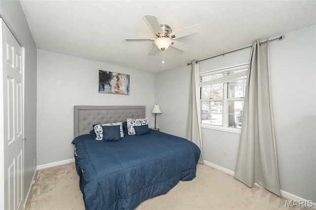 carpeted bedroom featuring baseboards and a ceiling fan