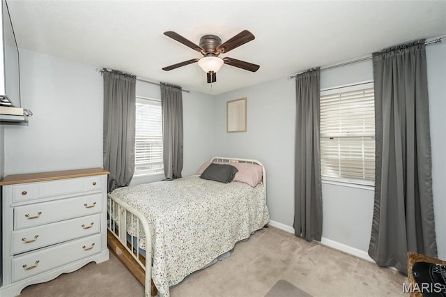 bedroom with light colored carpet, baseboards, and a ceiling fan