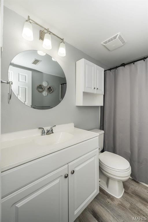 full bath with wood finished floors, toilet, and vanity