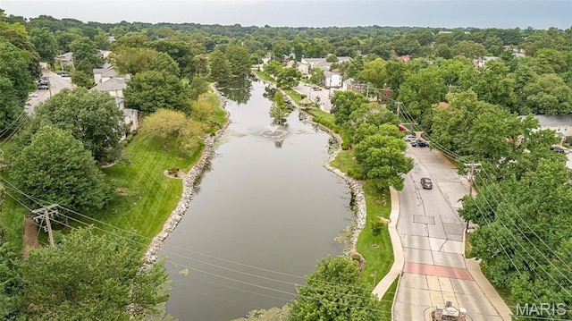 drone / aerial view of a nearby body of water and a forest