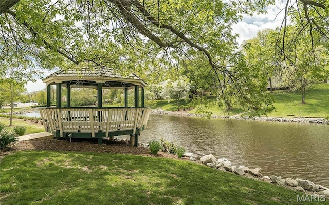 dock featuring a gazebo, a water view, and a lawn