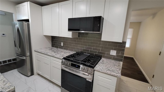 10216 Pannell Dr, Saint Louis, MO 63136 - kitchen featuring stainless steel appliances, light marble finish flooring, light stone countertops, and baseboards