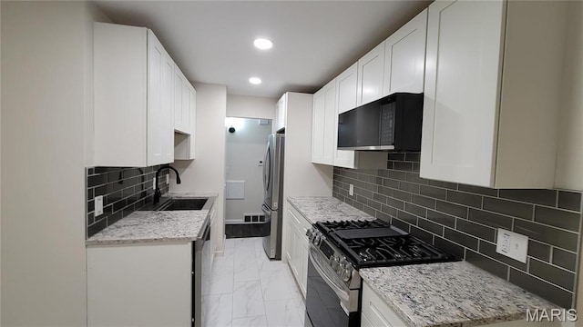 10216 Pannell Dr, Saint Louis, MO 63136 - kitchen featuring stainless steel appliances, a sink, light marble finish flooring, light stone countertops, and recessed lighting