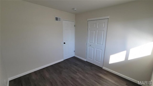 10216 Pannell Dr, Saint Louis, MO 63136 - unfurnished bedroom featuring dark wood finished floors, baseboards, and a closet
