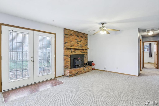 29 Zinnia Dr, Belleville, IL 62221 - unfurnished living room featuring a wood stove, baseboards, carpet floors, ceiling fan, and french doors