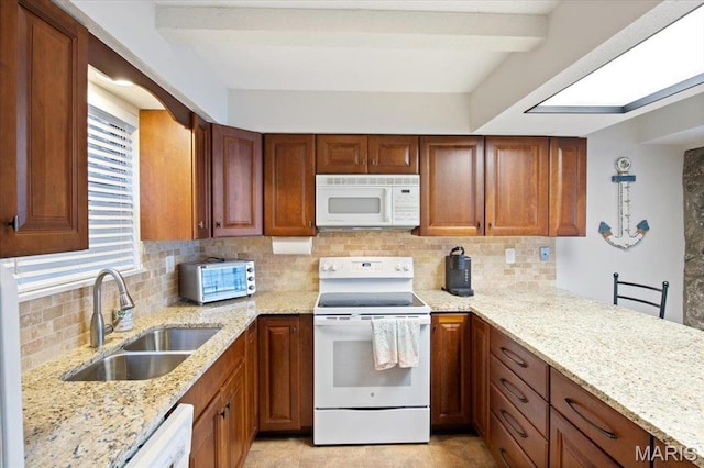 kitchen with white appliances, a sink, backsplash, light stone countertops, and brown cabinets