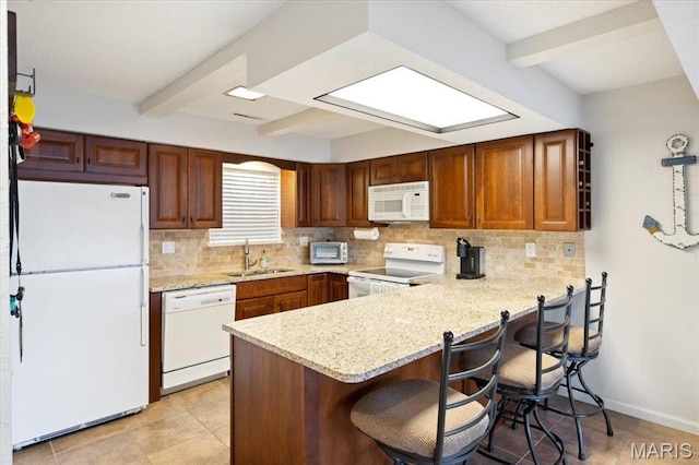 kitchen with white appliances, a peninsula, a sink, beamed ceiling, and backsplash