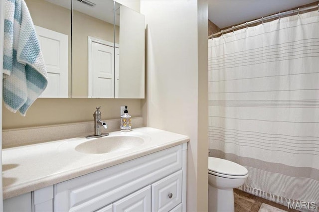 bathroom featuring vanity, toilet, and curtained shower