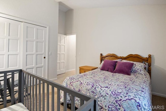 bedroom featuring carpet, baseboards, lofted ceiling, and a closet