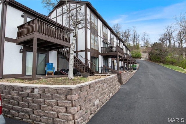view of property exterior featuring stairs, a deck, and stucco siding