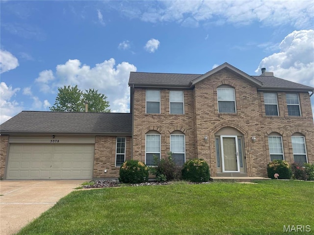 3078 Willow Creek Estates Dr, Florissant, MO 63031 - view of front of house featuring brick siding, concrete driveway, an attached garage, and a front lawn