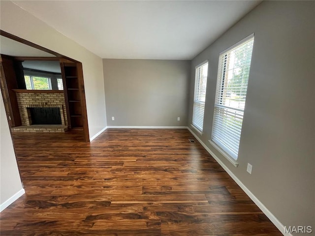 3078 Willow Creek Estates Dr, Florissant, MO 63031 - unfurnished living room with baseboards, dark wood-style flooring, and a fireplace