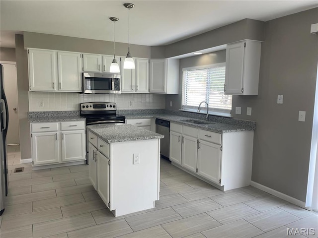 3078 Willow Creek Estates Dr, Florissant, MO 63031 - kitchen featuring appliances with stainless steel finishes, a sink, backsplash, and white cabinetry