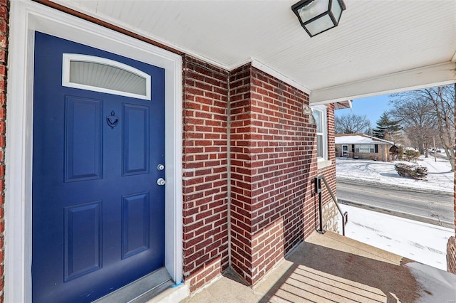 7001 Plymouth Ave, Saint Louis, MO 63130 - snow covered property entrance with covered porch and brick siding