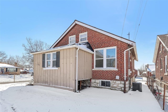 7001 Plymouth Ave, Saint Louis, MO 63130 - snow covered rear of property featuring fence, cooling unit, and brick siding