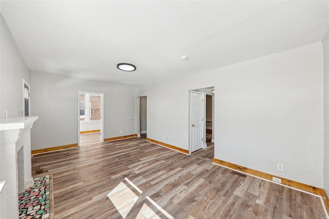 7001 Plymouth Ave, Saint Louis, MO 63130 - unfurnished living room with baseboards, wood finished floors, and a fireplace
