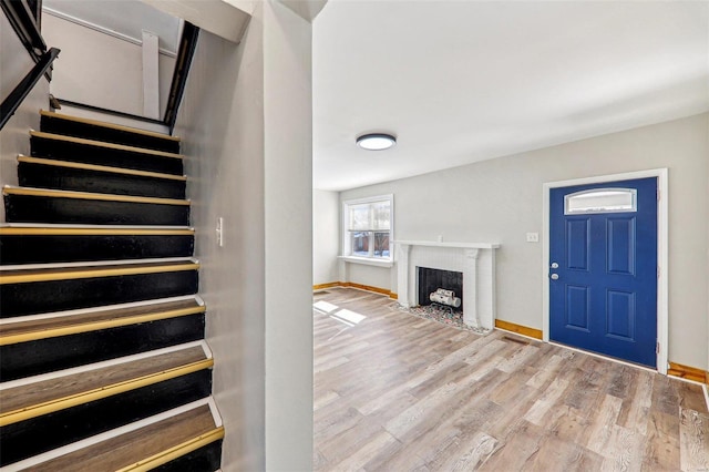 7001 Plymouth Ave, Saint Louis, MO 63130 - stairway with a fireplace with flush hearth, wood finished floors, and baseboards