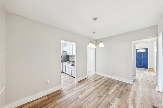 7001 Plymouth Ave, Saint Louis, MO 63130 - unfurnished dining area featuring light wood-style flooring and baseboards