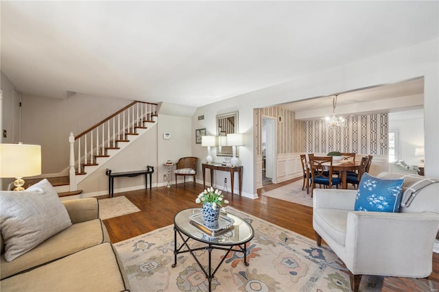 living room featuring stairs, a chandelier, and wood finished floors