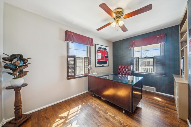 home office with healthy amount of natural light, wood finished floors, a ceiling fan, and baseboards