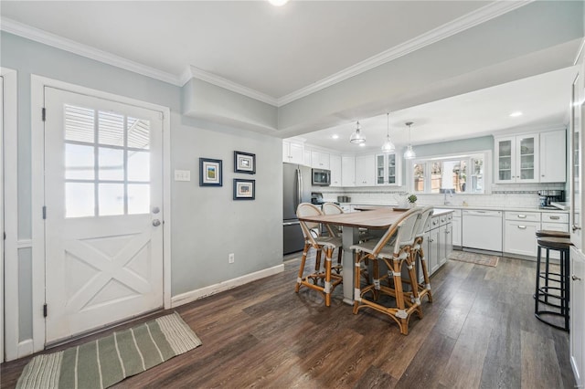 dining space featuring dark wood-type flooring, crown molding, baseboards, and recessed lighting