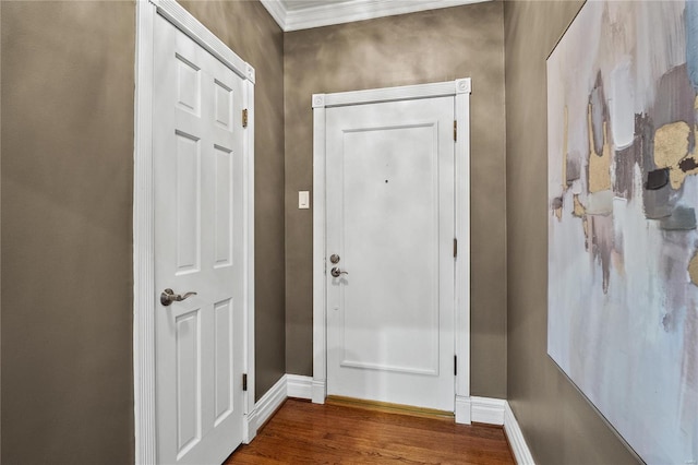 doorway to outside featuring baseboards, wood finished floors, and crown molding