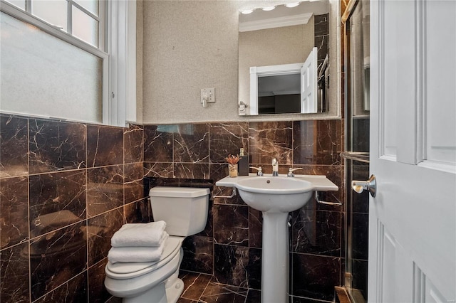 bathroom with toilet, tile walls, and ornamental molding