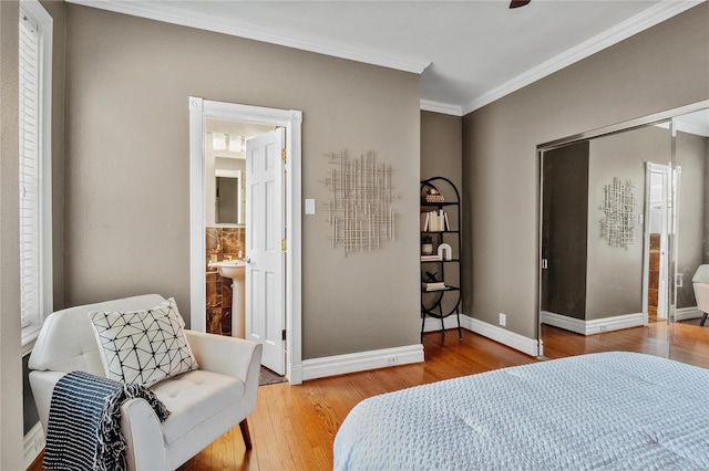 bedroom featuring wood finished floors, crown molding, and baseboards
