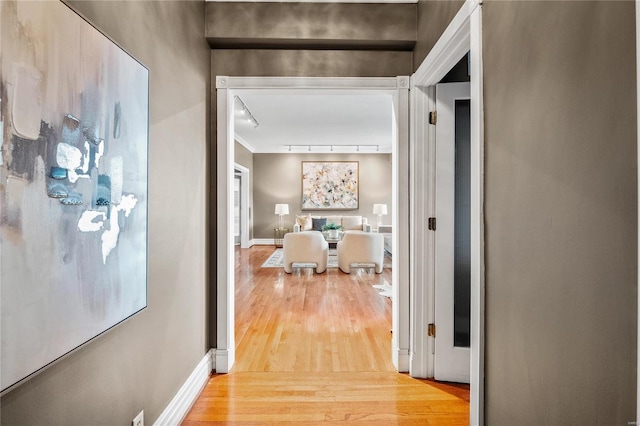 corridor featuring wood finished floors and baseboards