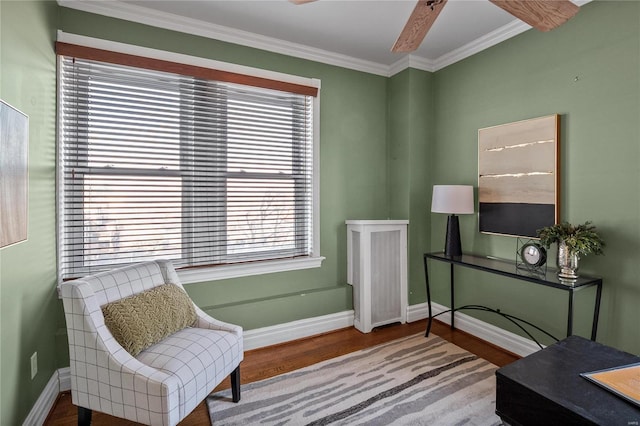 sitting room featuring wood finished floors, baseboards, plenty of natural light, and ornamental molding