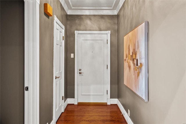 doorway with wood finished floors, crown molding, and baseboards