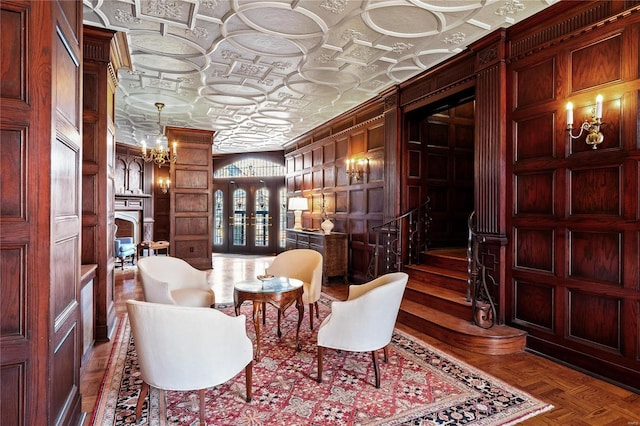 living area featuring an ornate ceiling, stairway, wood walls, and crown molding
